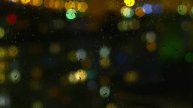 Yağmurlu günler, yağmur damlaları pencere yüzey ve renkli bokeh ampul üzerinde