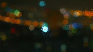 Yağmurlu günler, yağmur damlaları pencere yüzey ve renkli bokeh ampul üzerinde