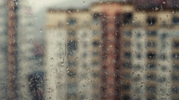 Binalar karşı pencere camı üzerinde yağmur damlaları — Stok video