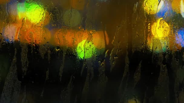 Imagen de gotas de lluvia en la ventana por la noche en la ciudad — Vídeos de Stock