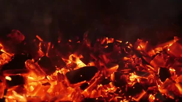 Kohlen schwelen in einem Kohlenbecken, eine Person bewegt sie mit einem Poker — Stockvideo