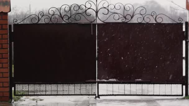 Железные ворота во время дождя и снега, разделенные на 2 части видео — стоковое видео