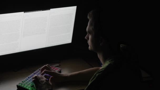 Retrato del redactor, trabajador, hombre ocupado en camisa trabajando por la noche, mirando la pantalla, sentado en la estación de trabajo, cogido de la mano en el teclado — Vídeo de stock