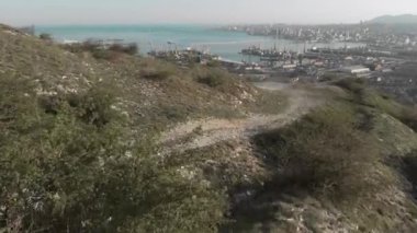 bir dağ üzerinde oturan bir turist quadrocopter helikoptere ihtiyacım var, bir drone Novorossiysk Limanı, Novorossiysk şehir, Rusya, çimento Bay çekim.