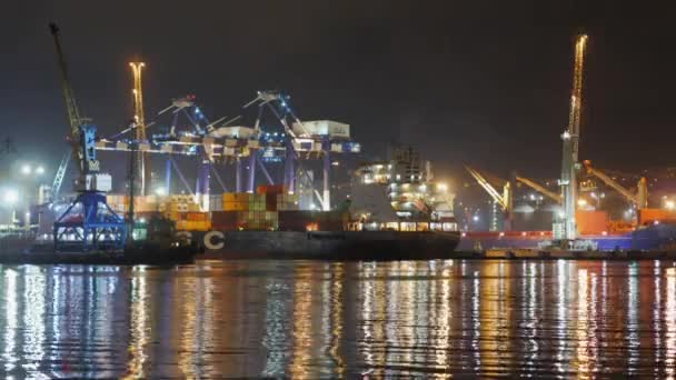 Embarcación de contenedores en puerto de mar profundo por la noche, logística de exportación de importación de negocios y transporte de Internacional por buque de carga de contenedores en el mar abierto, lapso de tiempo de vista aérea — Vídeo de stock