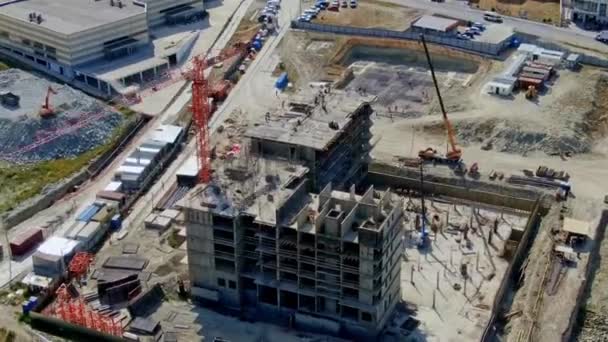 Baustelle mit Blick auf die Autobahn. Hyperlapse Videoaufnahmen mit Drohnen. neues Haus in der Nähe der Straße und Wohngebiete, Mikrodistrikte. im Kreis fliegen. — Stockvideo