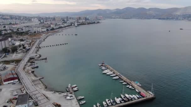 Marina a Fekete-tengeren. Oroszország, Novorossiysk. Video lövés a levegőből, kamera lassan mozog lefelé. Horgonyzott jachtok — Stock videók