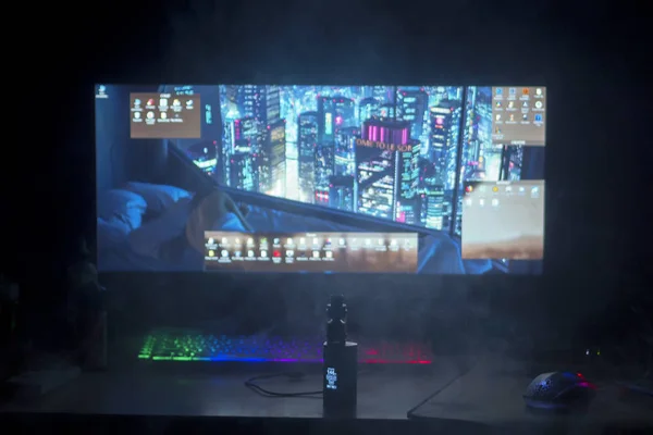 Lugar de trabajo, espacio de juego, teclado y ratón con luz de fondo y pantalla grande, vapor en primer plano — Foto de Stock