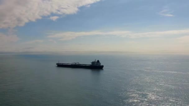 Luftaufnahme Verankerung des Tankers im Ankerbereich. Drohne fliegt bei bewölktem Himmel über Wasser, Kamera bewegt sich seitwärts auf einsamen Tanker zu, der an sonnigen Tagen vor Anker liegt — Stockvideo