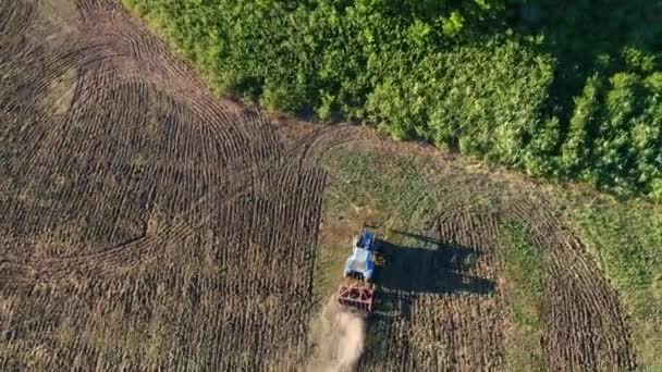Traktor pflügt ein Feld entfaltet Schießen von oben auf einer Drohne. Kleiner Traktor dreht sich auf dem Feld — Stockvideo