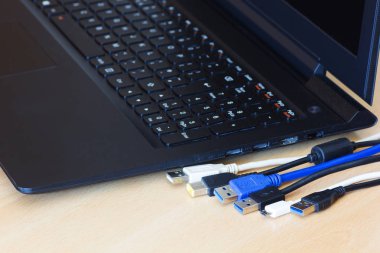 Birçok farklı usb kabloları ve ahşap arka plan üstünde laptop.