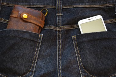 Cep telefonu ve arka ceplerinde kot pantolon deri cüzdan.