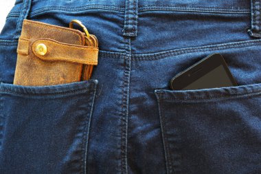 Cep telefonu ve arka ceplerinde kot pantolon deri cüzdan.