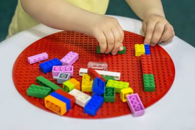 Oluşturucu renk tuğla ile oynayan küçük çocuk elleri