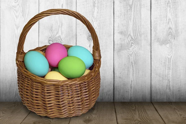 Easter basket filled with painted eggs over wooden table