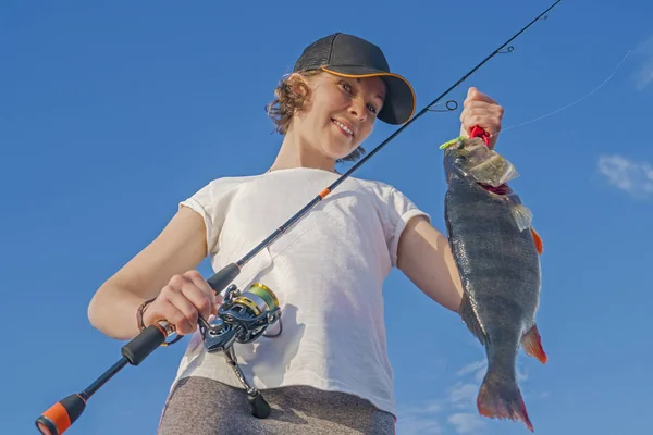 Happy fisher girl with perch fish trophy at the boat — Stock Photo, Image