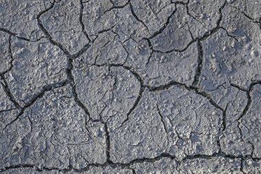 Kurak -lık. Kuru zeminde çatlaklar. Doğal gri arka plan