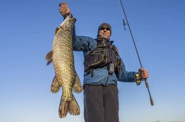 Glad fiskare som håller stor gädda fisk trophy och fiskespö — Stockfoto