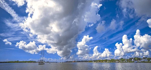 Гавань панорама с деревней на берегу и яхты и лодки на воде . — стоковое фото