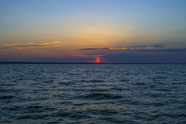 Pôr-do-sol colorido com céu azul nublado acima do mar. Paisagem de relaxamento — Fotografia de Stock