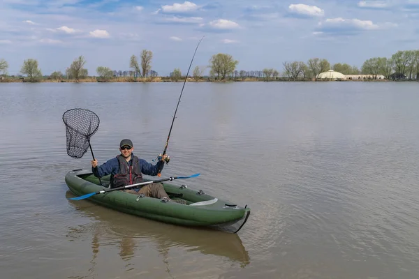 Kayak pesca en el lago. Pescador en barco inflable con aparejos de pesca . — Foto de Stock