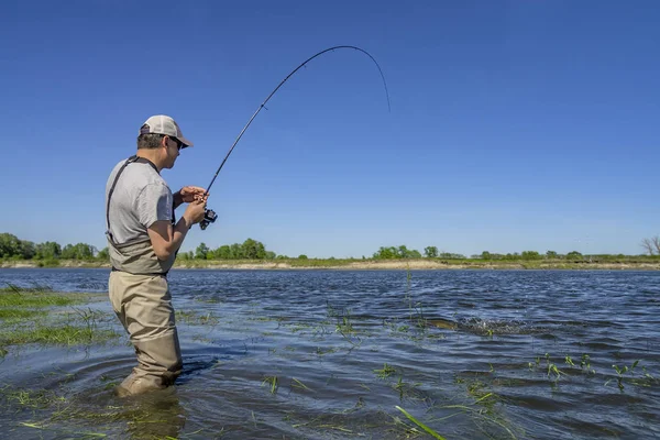 Великий щука рибалка. Рибалка ловить рибу у воді на річці — стокове фото