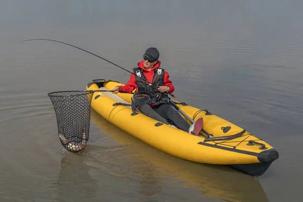 Kayak pesca en el lago. Pescadora con lucio en barco inflable con aparejos de pesca . — Foto de Stock