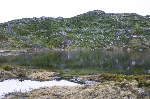 Norveç'teki dağlar gölünde yalnız balıkçı. Yürüyüş backgroun — Stok fotoğraf