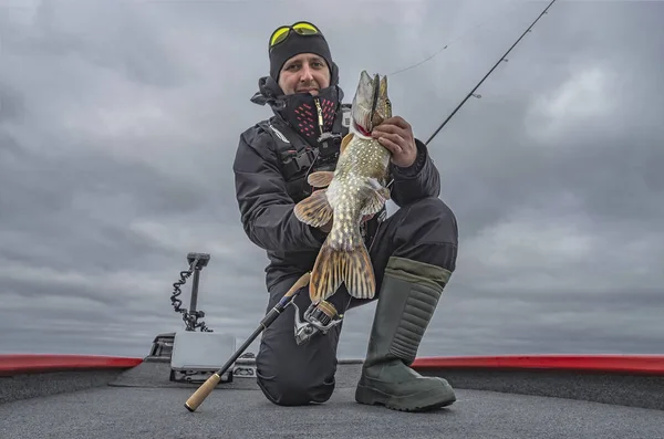 Pesca de lucio. Pescador feliz con gran trofeo de pescado en el barco con tacleadas — Foto de Stock