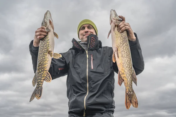 Hechtfischen. glücklicher Angler mit großer Fischtrophäe am Boot mit Angeln — Stockfoto