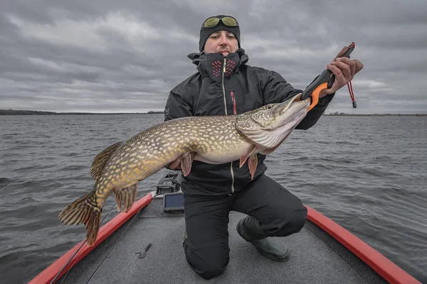 Gäddfiske. Lycklig fiskare med stor fisk Trophy på båten med tacklingar — Stockfoto