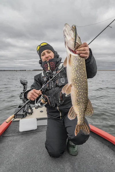 Snoek vissen. Gelukkige visser met Big Fish Trophy op de boot met pakt — Stockfoto