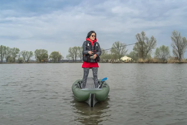 湖でのカヤック釣り.釣りタックルで膨脹可能なボートの漁師の女性. — ストック写真