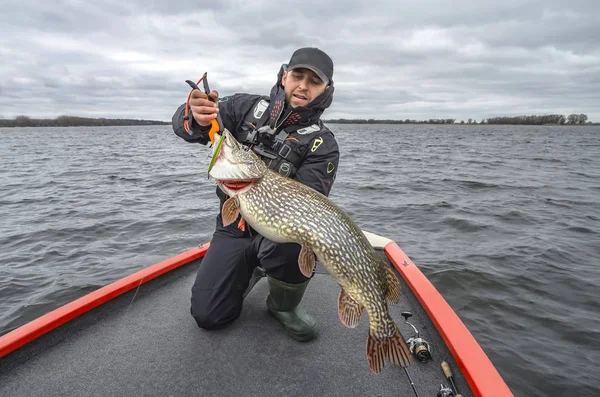 Gäddfiske. Lycklig fiskare med stor fisk Trophy på båten med tacklingar — Stockfoto