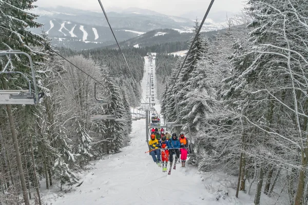 Ukraine, bukovel - 2018 년 12 월 15 일. 많은 스노 보더와 스키를 타는 사람들 이 스노보드를 타고 엘레 베 이터를 타고 스노우 힐로 갑니다. 겨울에 카르파티아 산맥에서 스키를 타는 모습 — 스톡 사진