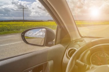 Araba gezisi. Yan aynada yol görünümü yansıması. Sunshine tonda fotoğraf