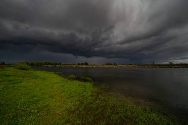 Fırtınadan önce doğanın inanılmaz manzarası. Vahşi nehrin üzerindeki kara bulutlar. Dramatik hava