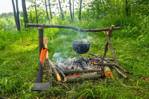 Fogueira Acampamento Com Caldeirão Lenha Com Machado Floresta Caminhadas Fundo — Fotografia de Stock