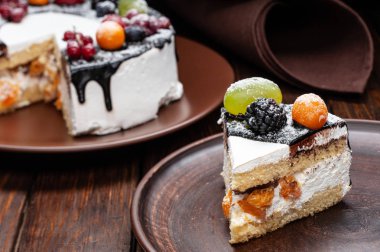 Meyveli kek. Ahşap masa üzerinde meyve ve çilek dekorasyonu ile lezzetli pasta