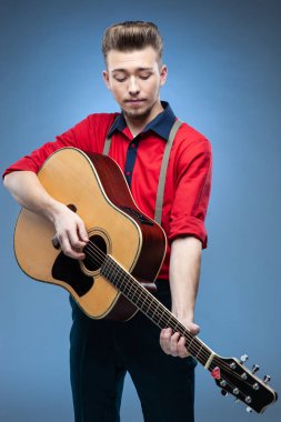 Genç adam giyinmiş rock'n'roll veya rockabilly tarzı. Retro tarzı, saç modeli, jartiyer, gömlek.