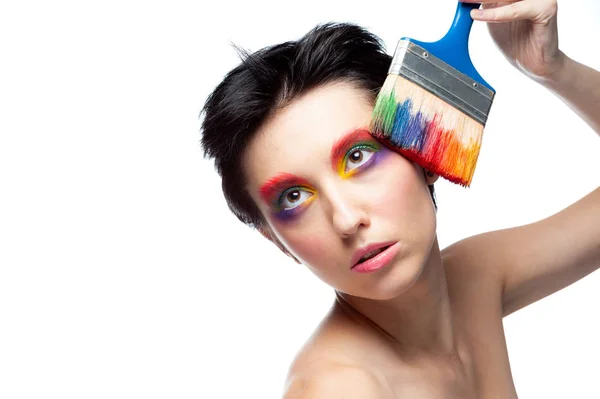Mädchen mit Fantasie-Make-up hält einen Pinsel in der Hand — Stockfoto