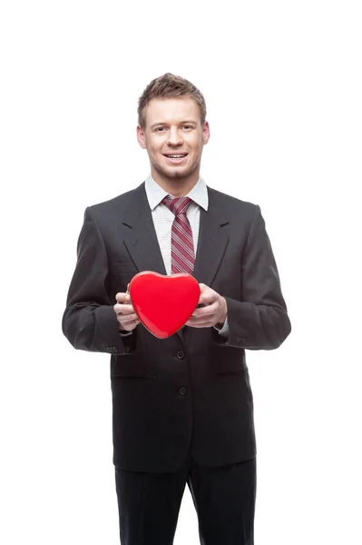 Seductive businessman holds and shows  red heart — Stock Photo, Image