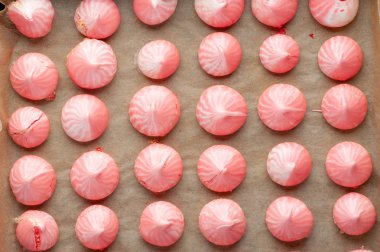 Destek kağıtları üzerinde pembe ahududu meringues.  