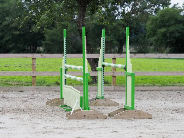 A single show jump fence in a typical riding arena.