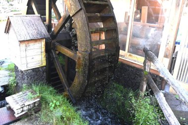 Japon su değirmeni manzarası. Su çarkına güç aktaran ahşap dişliler ve değirmen unu için havan topları yerleştirildi..