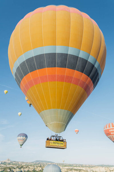 CAPPADOCIA, TURKEY - 28 APRIL 2018: Low angle view of hot air balloons flying in blue sky, Cappadocia, Turkey