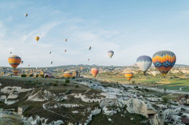 front view of hot air balloons flying over cityscape, Cappadocia, Turkey clipart
