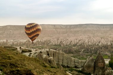 scenic view of hot air balloon flying over stone formations in valley of Cappadocia, Turkey 