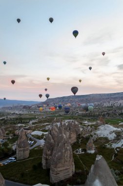front view of hot air balloons flying over stone formations, Cappadocia, Turkey clipart