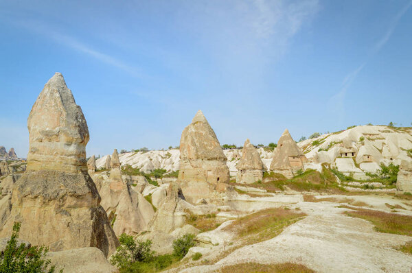 scenic view of stone formations in valley under blue sky, Cappadocia, Turkey